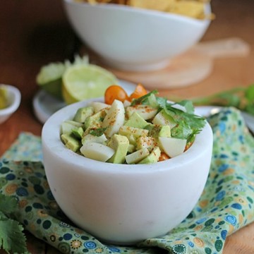 Vegan ceviche in white bowl on green napkin.