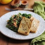 Grilled tofu slabs on plate with kale salad.