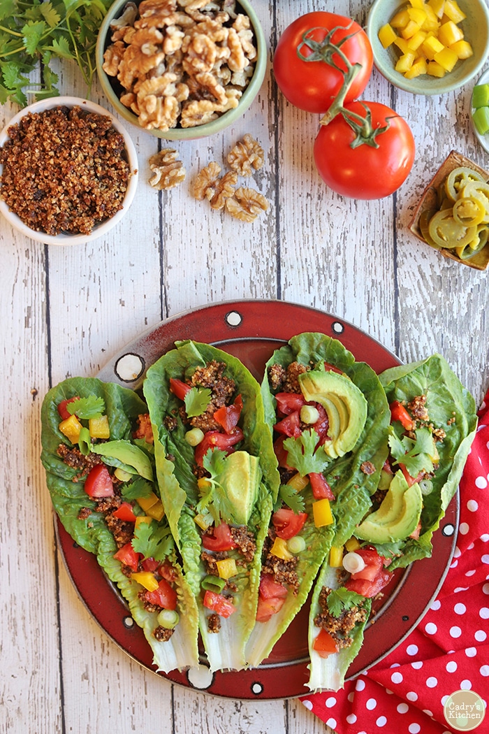 Platter of romaine leaves with walnut meat, avocado, and vegetables.