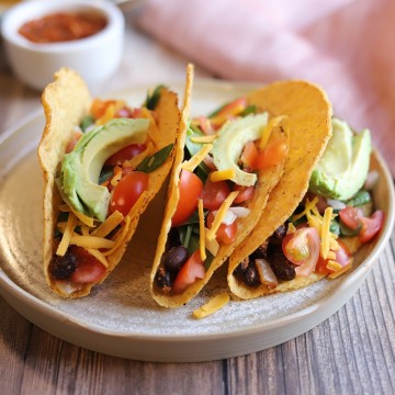 Black bean tacos on plate by napkin.