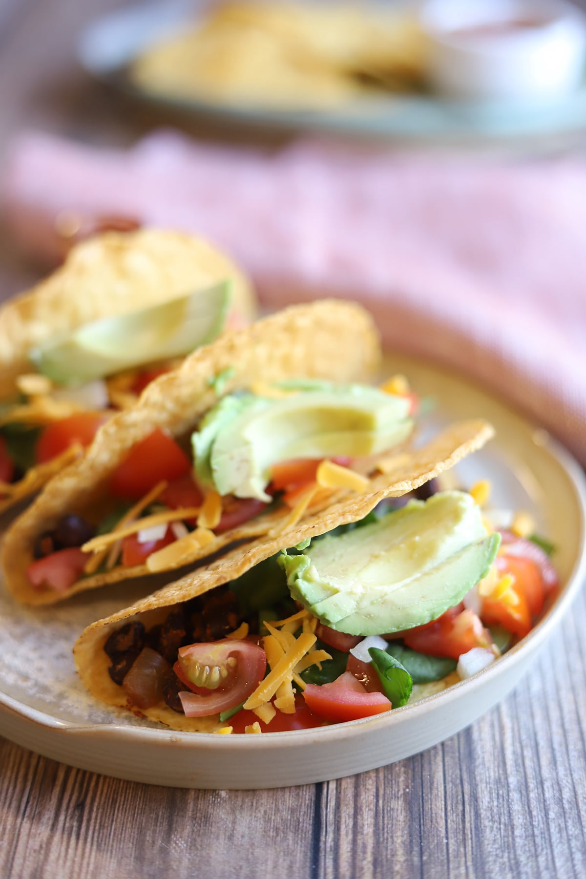 Black bean tacos stuffed with avocado, tomatoes, and non-dairy cheese.