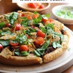 Text: Vegan taco pizza with black beans. Close-up vegan taco pizza with lettuce, tomatoes, and chips.