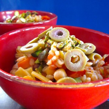 Barley paella in bowl with sliced olives.