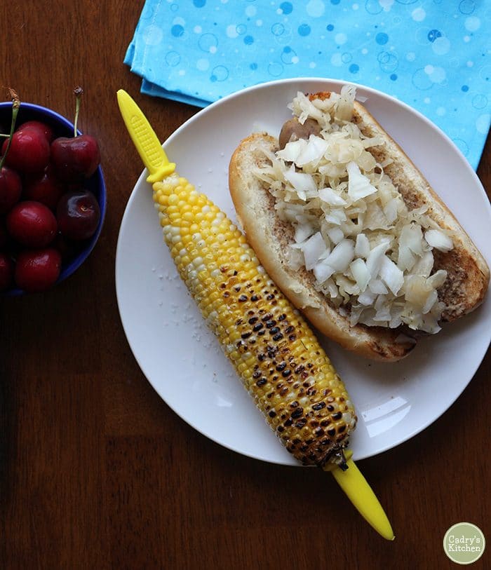 Overhead shot of grilled corn on the cob and Field Roast sausage with sauerkraut.