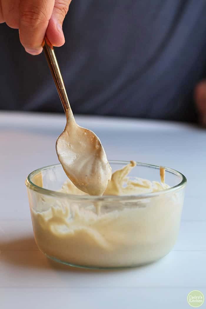 Cashew cream in Pyrex with spoon.