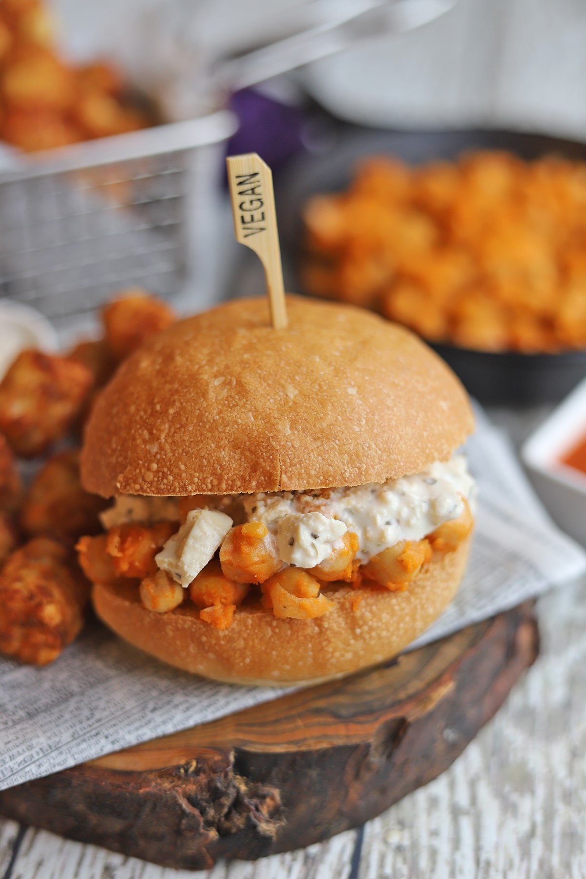 Buffalo chickpea sandwich topped with vegan blue cheese dressing.