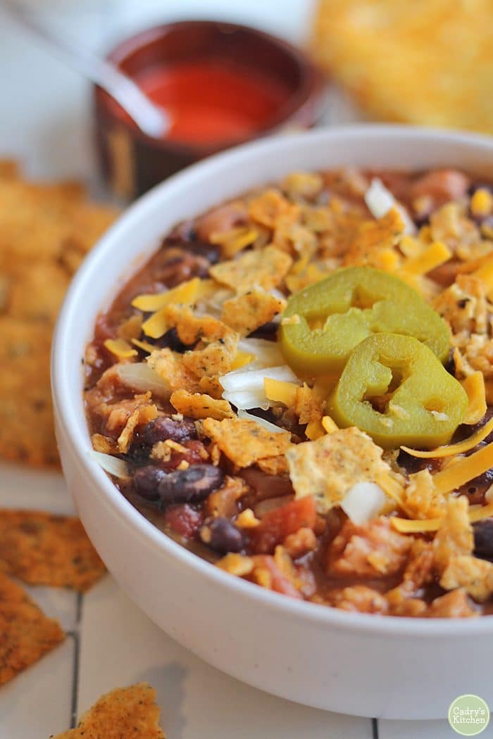 Close-up chili with Soy Curls & beans in bowl with jalapeno pepper slices.