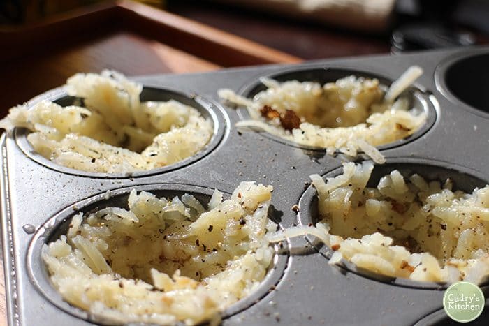 Grated potatoes in muffin cups for breakfast nests.