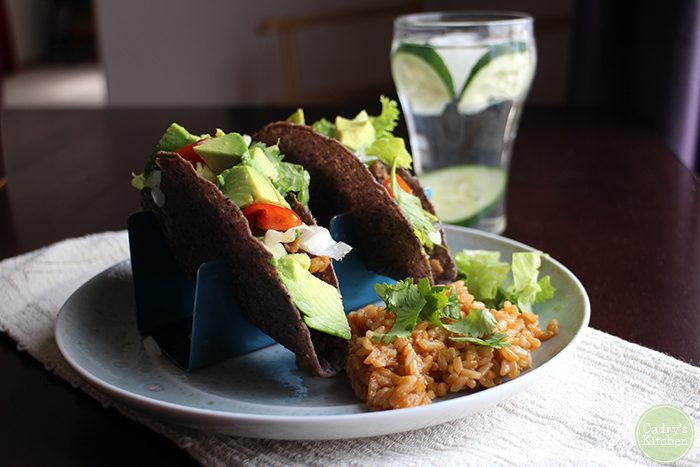 Tacos with calypso beans and brown rice on plate.