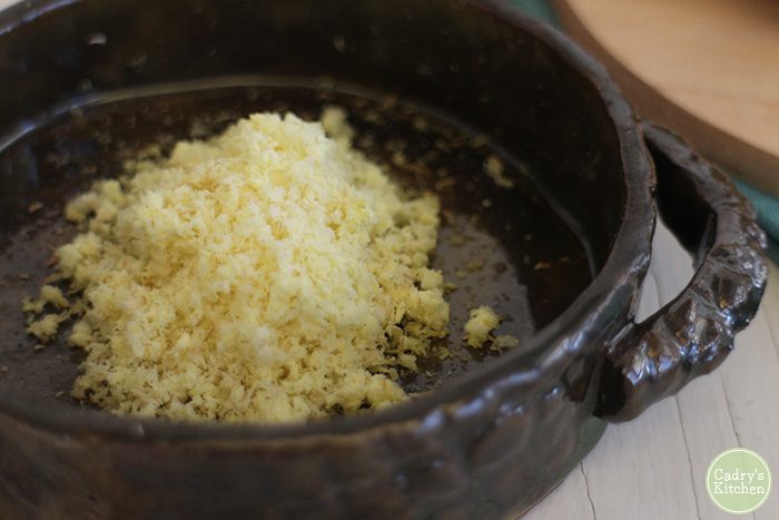 Finely grated ginger root in bowl.