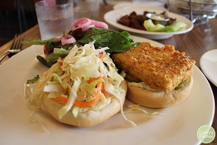 Battered tofu sandwich with coleslaw and salad.