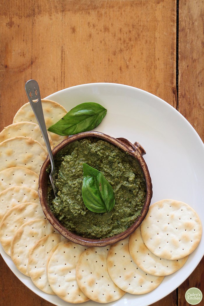 Overhead basil spread with crackers on plate.
