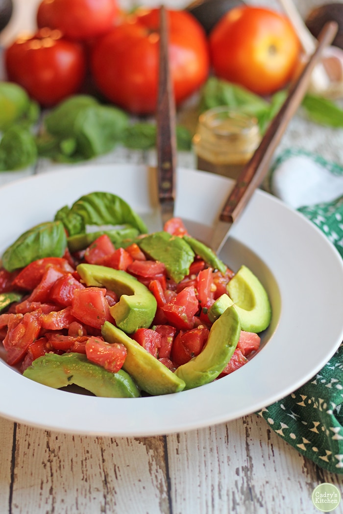 Vegan caprese salad in bowl with fresh basil.