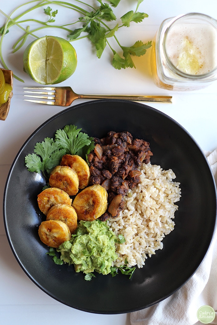 Overhead bowl with plantains, black beans, brown rice, and guacamole.