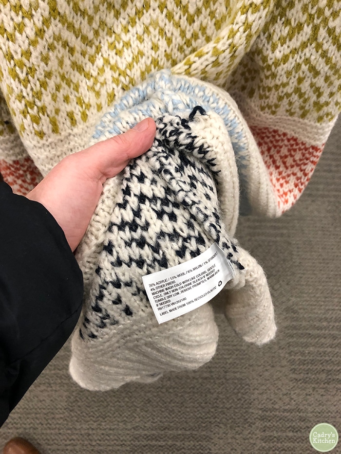 Sweater with tag showing it contains wool. Avoid wool when buying gifts for vegans.