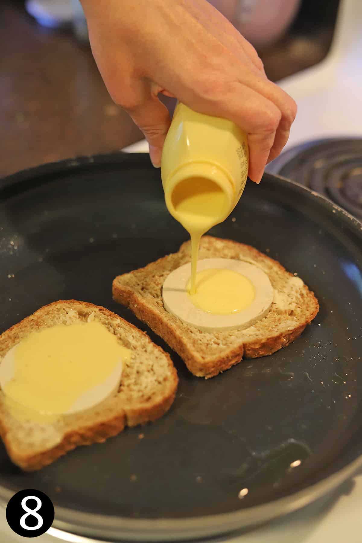 Just Egg being poured into tofu circles in bread.