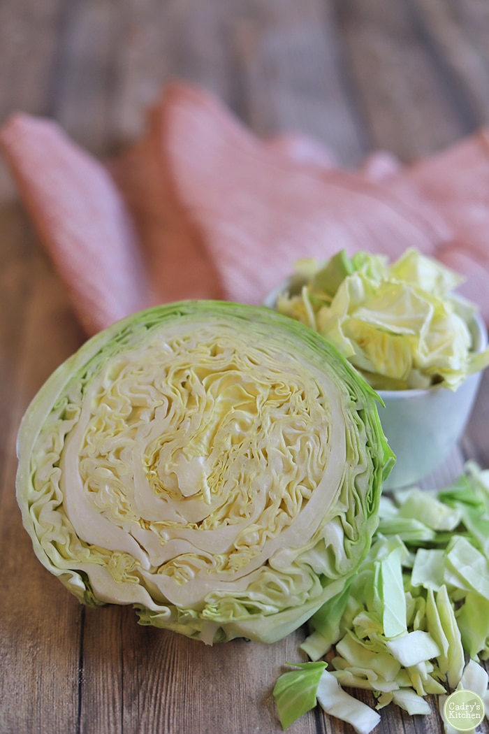 Cabbage head cut in half by chopped cabbage.