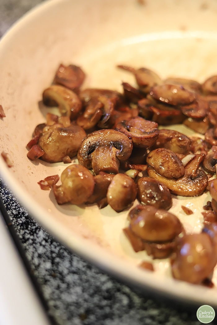 Close-up red wine mushrooms in skillet.