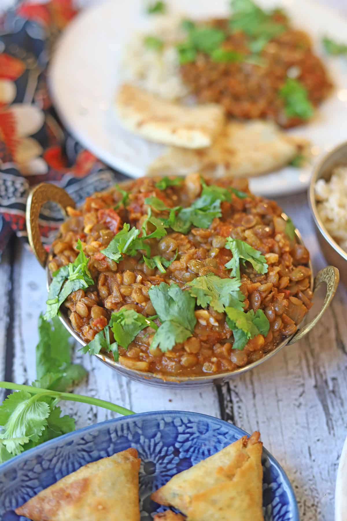 Brown lentil curry in karahi by samosas.