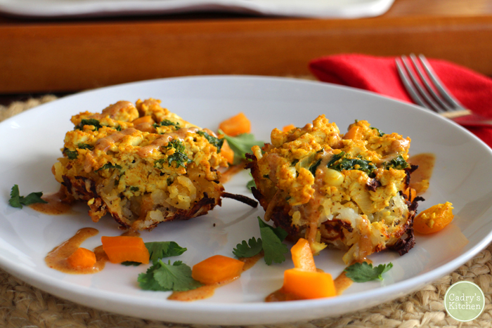 Breakfast nests with a creamy vegan queso on plate with bell peppers and cilantro.