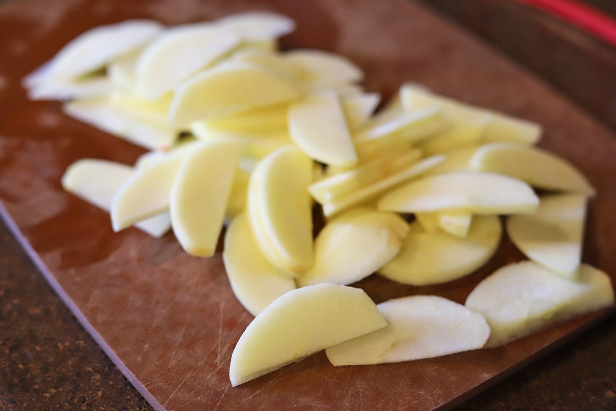 Thinly sliced apple on cutting board.