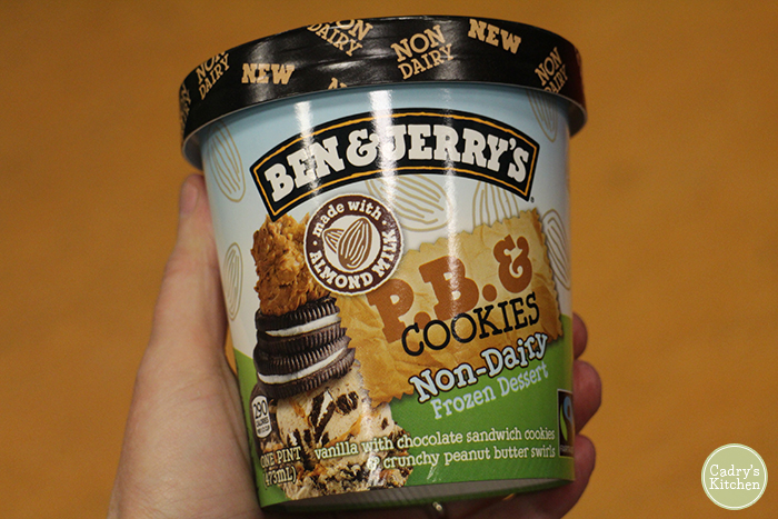 Hand holding container of Ben & Jerry's PB & Cookies non-dairy frozen dessert.