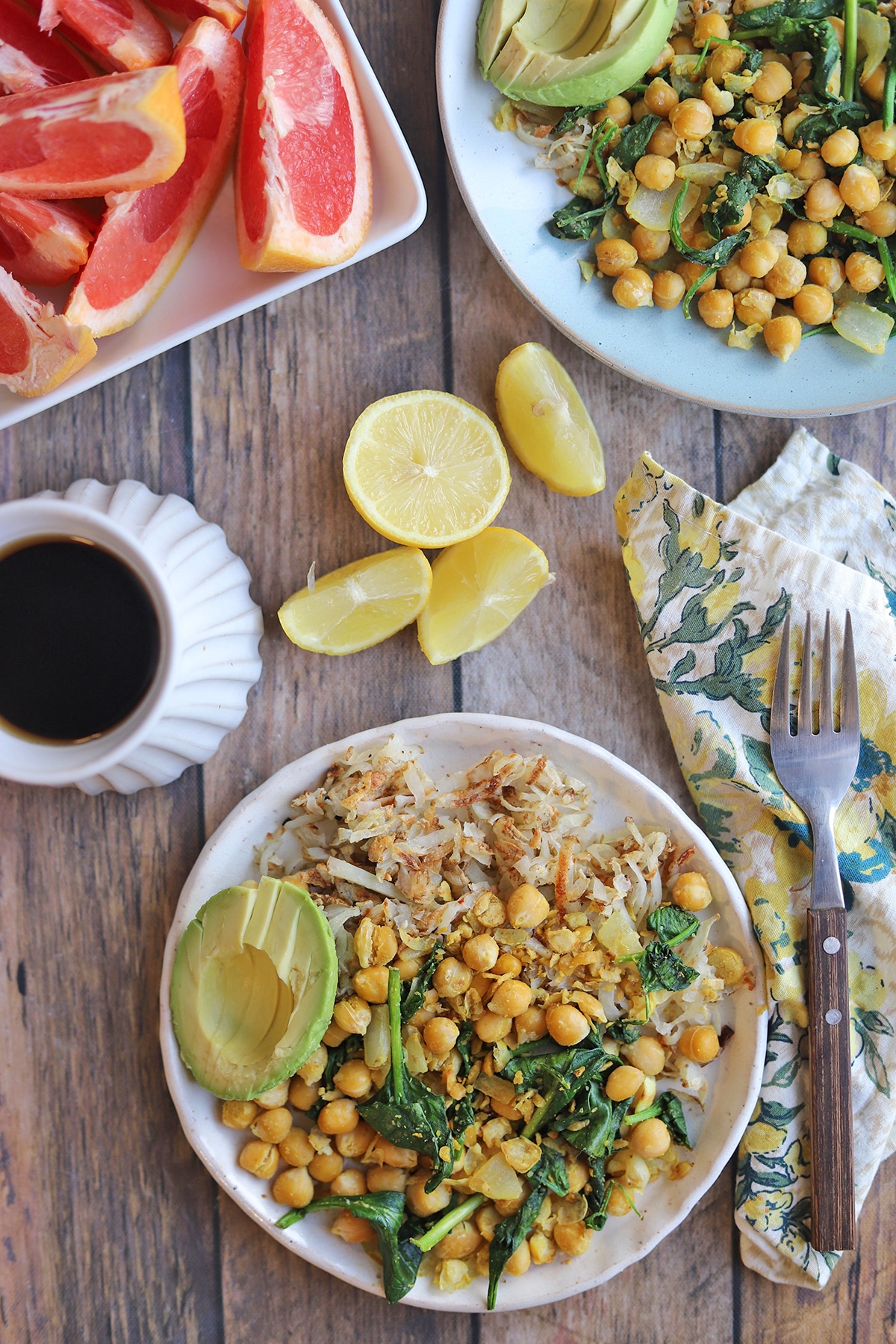 Overhead plates with chickpea scramble, sliced grapefruit, and coffee.