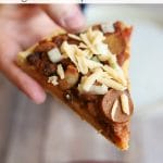 Text overlay: Chili dog pizza. Hand holding chili dog pizza with non-dairy cheese.