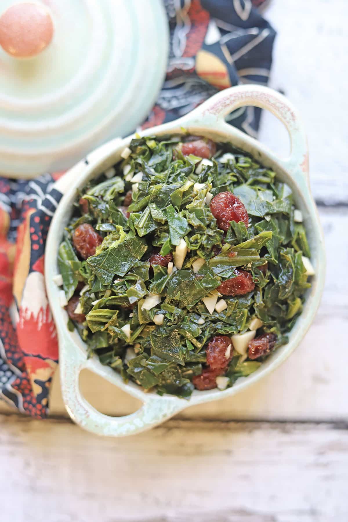Collard greens with dried cranberries in a serving dish.