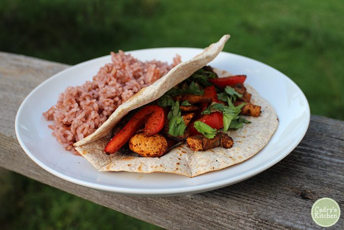 Fajitas on plate with pink rice.