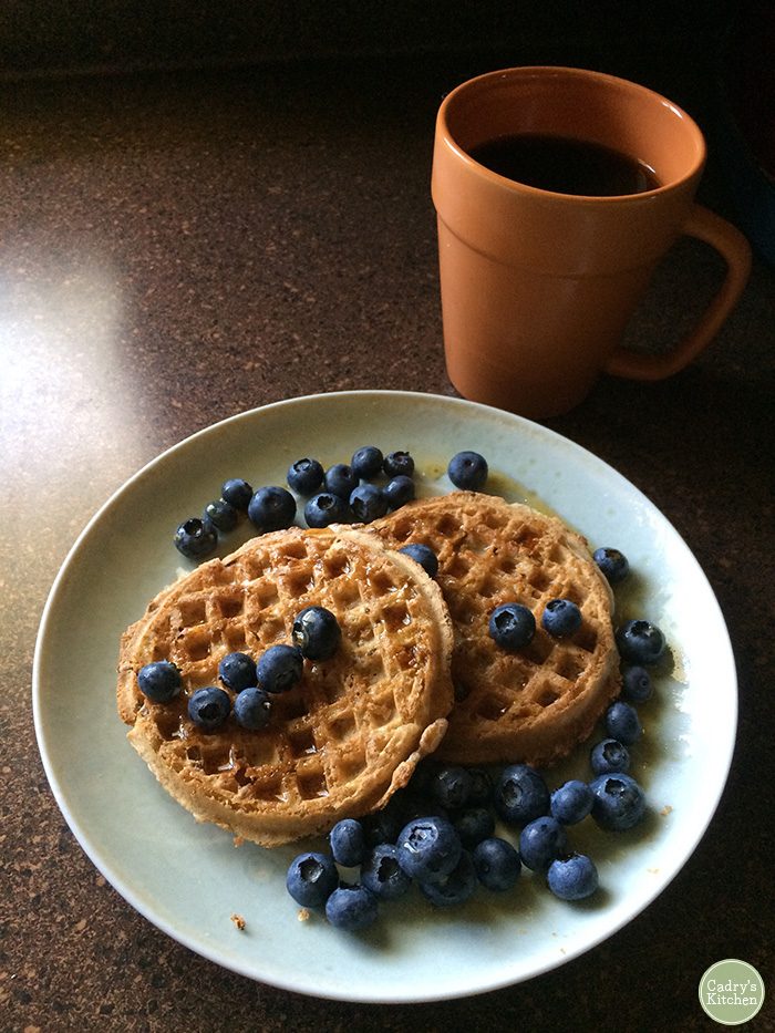 Waffles with blueberries and cup of coffee.