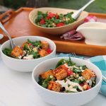 Salads in bowls on table by dressing.