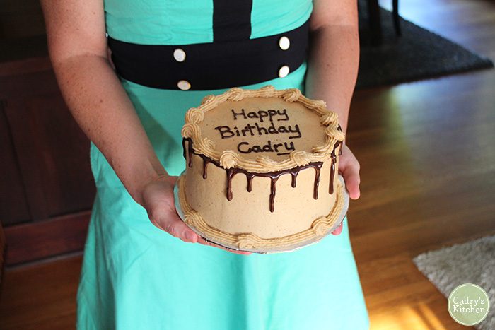 Cadry holding birthday cake from Back to Eden Bakery.