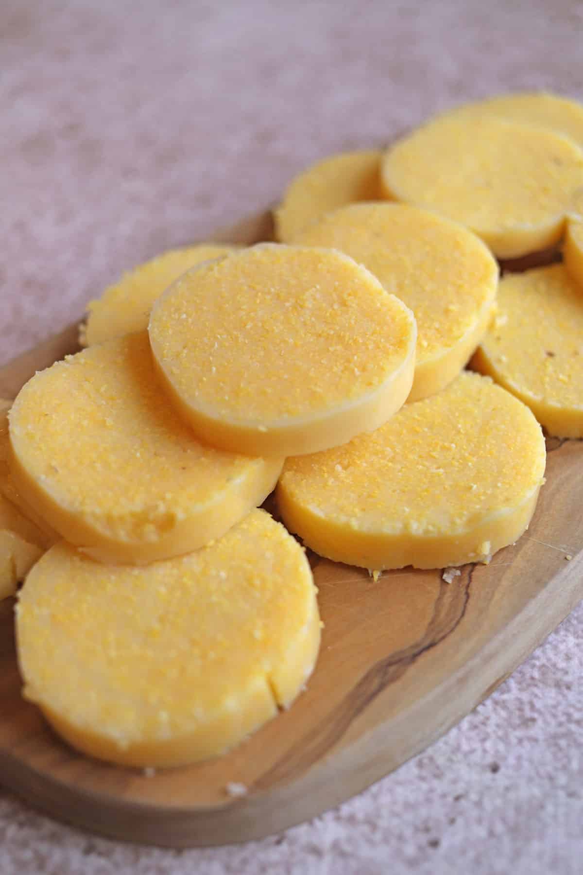 Rounds of polenta from tube on cutting board.