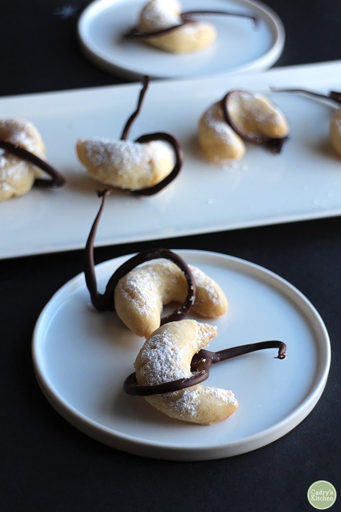 Crescent moon cookies on plates with chocolate lassos.