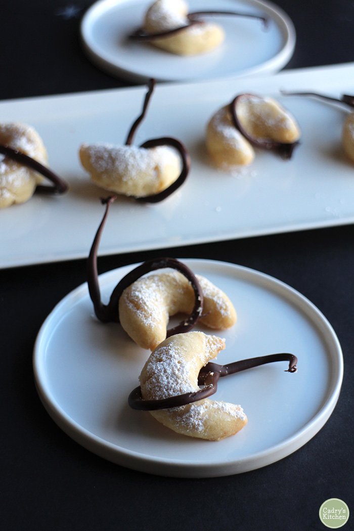 Crescent moon cookies on plates with chocolate lassos.