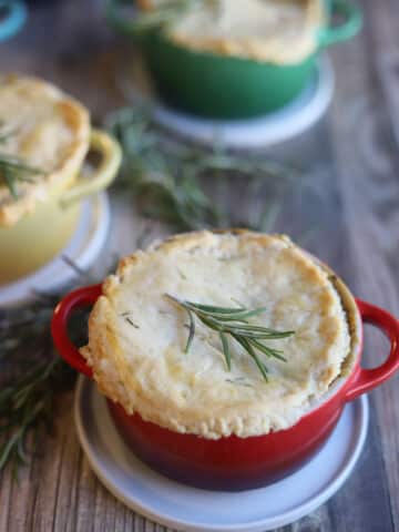 Chickpea pot pies on table, topped with rosemary.