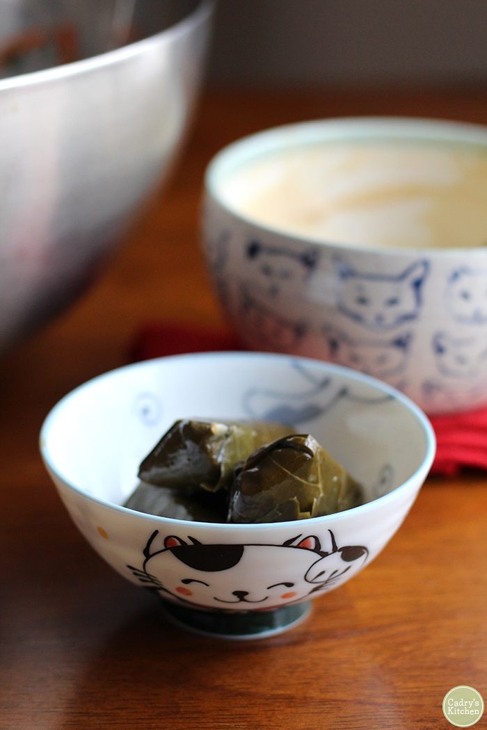 Dolmas in bowl with cat on it.