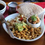 This hearty, vegan Austin breakfast is chock-full of flavor. It's packed with spicy scrambled tofu, creamy refried beans, potatoes, and guacamole. Savory breakfast lovers rejoice! | cadryskitchen.com