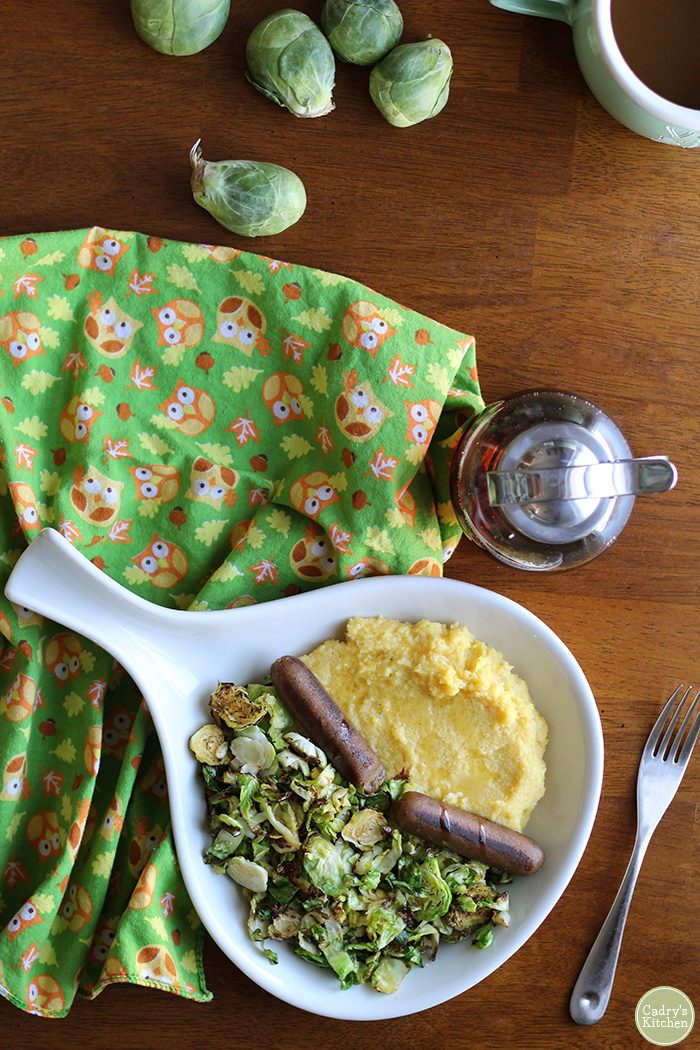 Overhead owl napkin, Brussels sprouts, maple syrup, and platter.