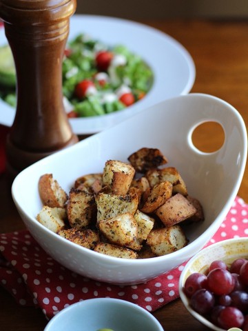 Air fryer croutons in a bowl on a polkadot napkin.