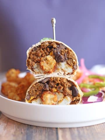 Vegan burrito halves stacked on top of each other.