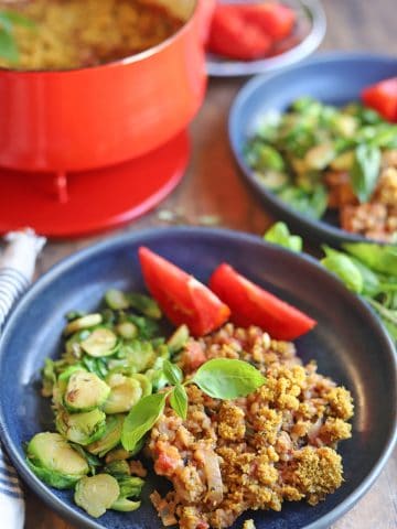Blue plate with Brussels sprouts, farro, and tomatoes.
