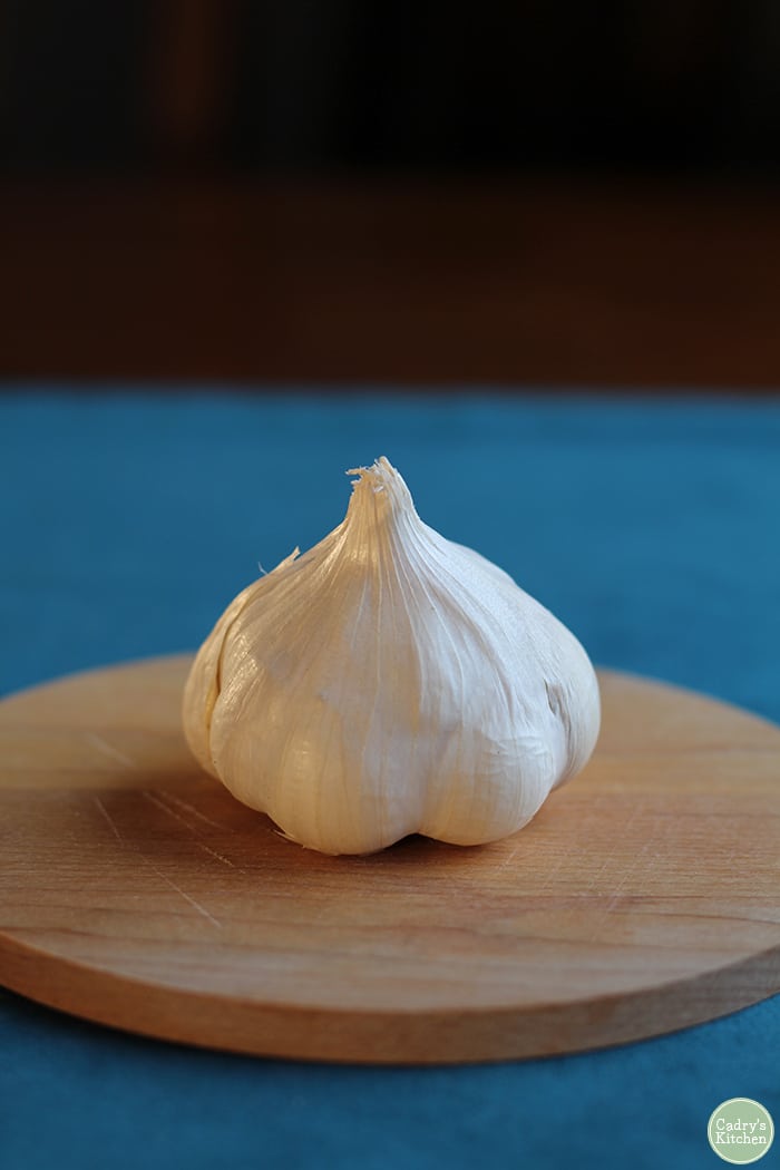 Garlic head on small cutting board.