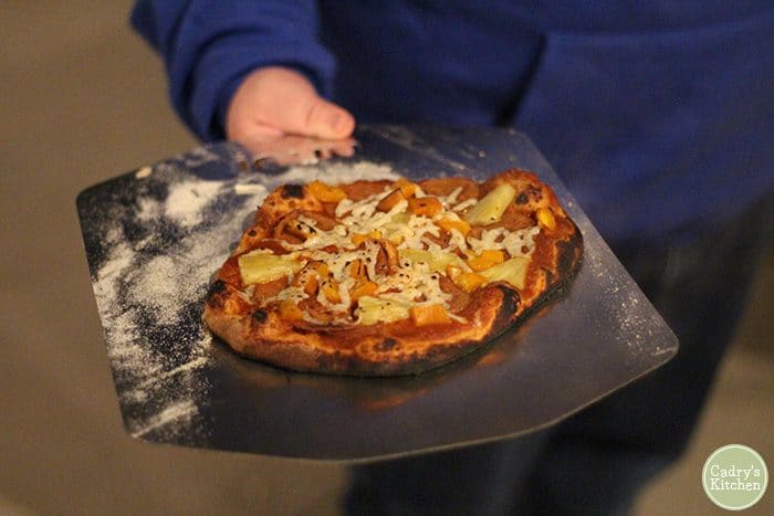 Vegan pizza from outdoor oven with blackened crust, Herbivorous Butcher mozzarella, and seitan pepperoni.