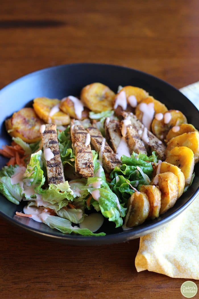 Green leaf lettuce salad with fried plantains, Beyond Meat chick'n strips, and sriracha ranch.
