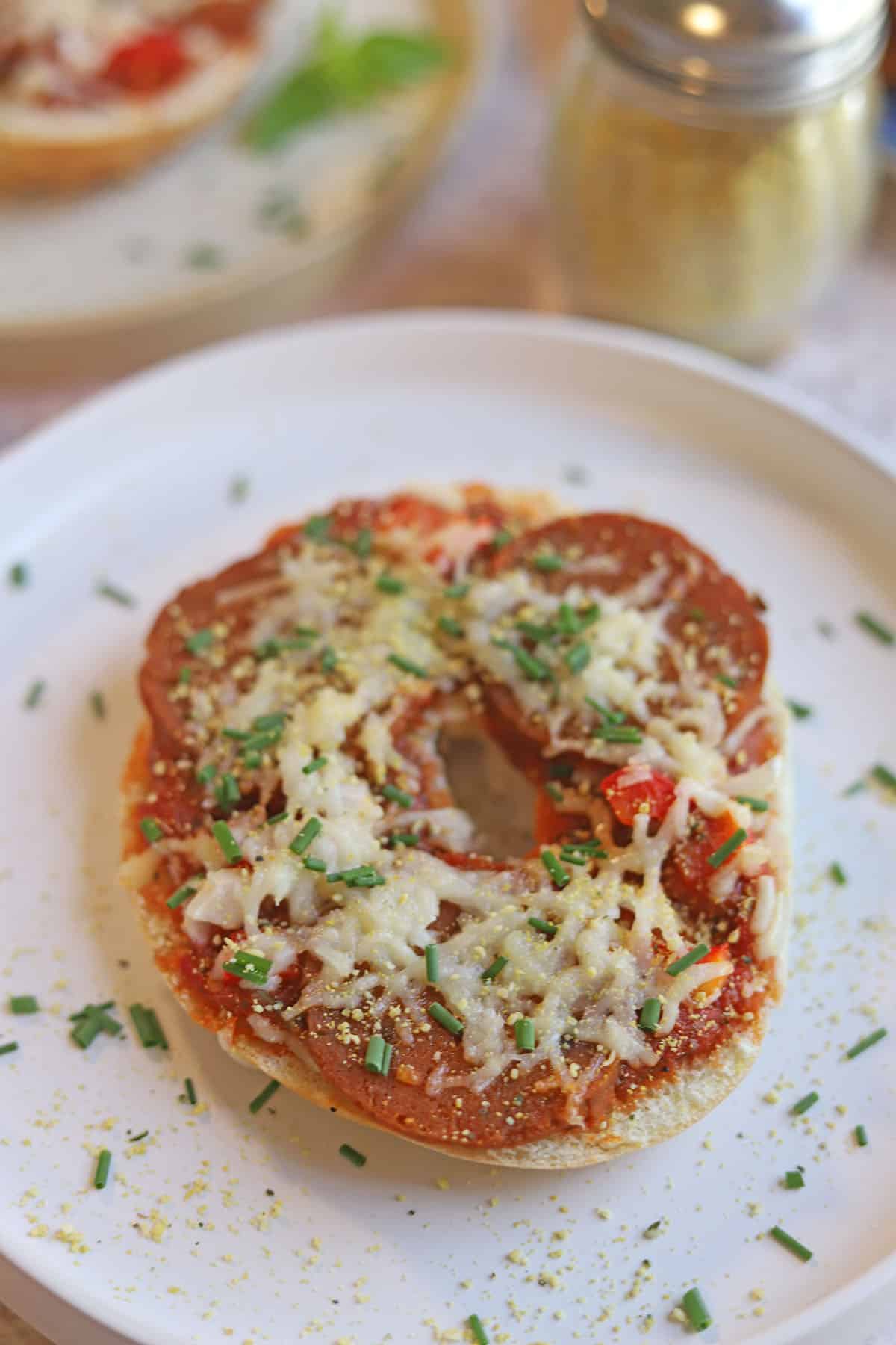 Vegan pizza bagel on plate.