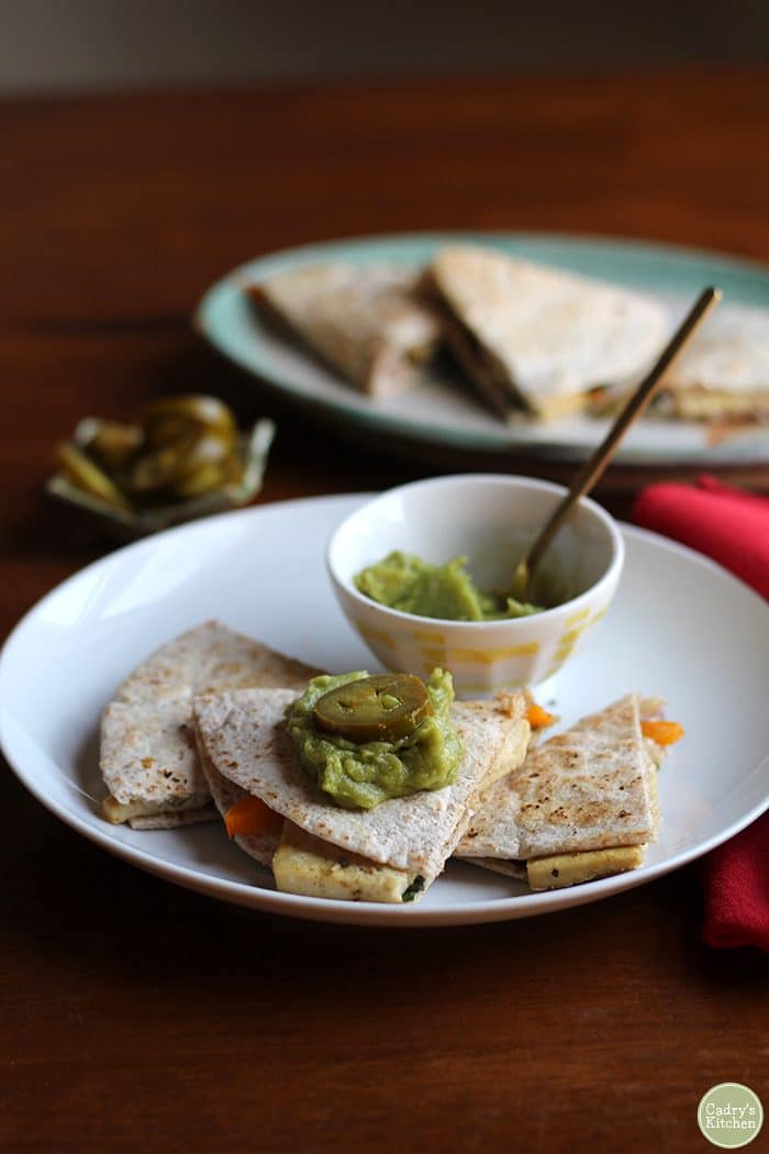 Vegan breakfast quesadilla with guacamole & jalapeno pepper slices.