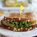 Close up vegan fried green tomato BLT on plate.