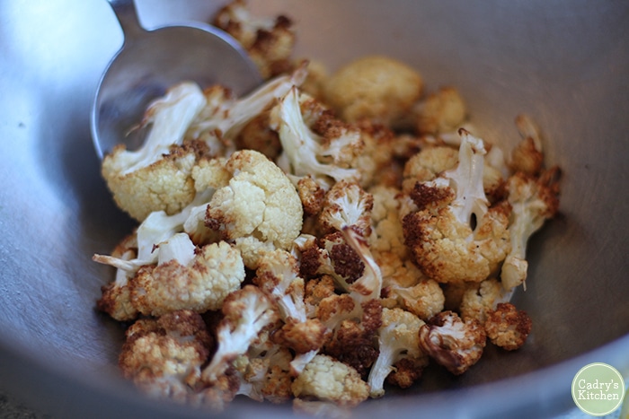 Roasted cauliflower in bowl, tossed with lemon juice, and salt.